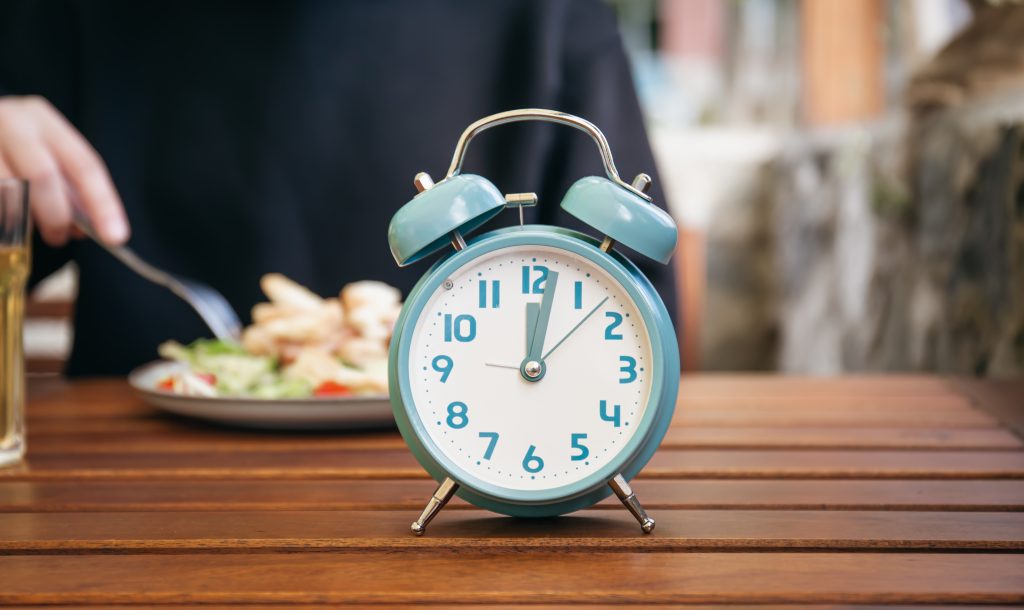 closeup alarm clock blurred food background scaled