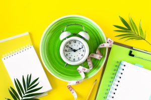 composition with plate alarm clock measuring tape colored background diet concept weight loss plan copy space scaled