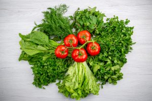 top view bundles fresh greens tomatoes with stem white background 1 scaled