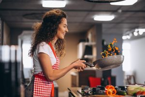 woman chef cooking vegetables pan scaled