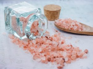 closeup shot jar wooden spoon with pink sea salt scaled