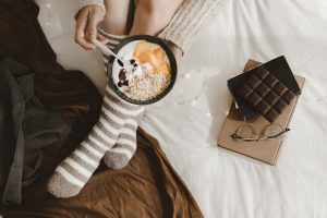 crop woman woman breakfasting near books chocolate scaled